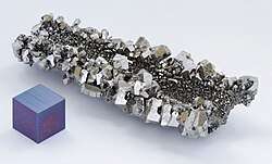 A lump of gray shining crystals with hexagonal facetting
