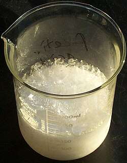 glass beaker of crystallized acetic acid