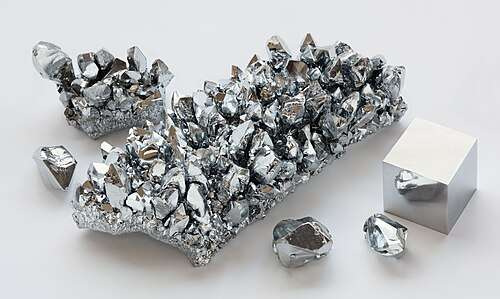 Metallic, reflective crystals of chromium metal and a cube of the same material