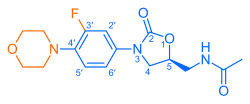 Skeletal formula of N-{[(5S)-3-[3-fluoro-4-(morpholin-4-yl)phenyl]-2-oxo-1,3-oxazolidin-5-yl]methyl}acetamide, highlighting the morpholino and fluoro groups in orange, with the rest in blue. The carbon atoms of the parent chain are numbered.