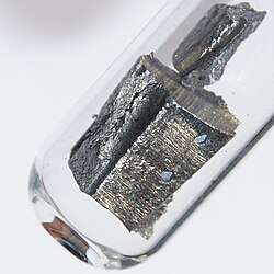 A piece of silvery metal in a glass tube
