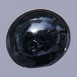 A bead of osmium, about 0.5 cm in diameter, displaying the metal's reflectivity