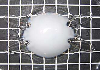 A PET bottle which has been heated by a candle and has recrystallized, making it opaque.