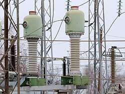 Minaret-like electrical devices with wires around them, thicker at the bottom