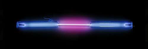 A clear tube with blue and purple light emanating from it