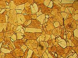 A mosaica pattern composed of components having various shapes and shades of brown.