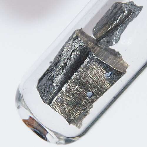 A piece of silvery metal in a glass tube
