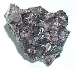 A black shiny lump of solid with uneven surface